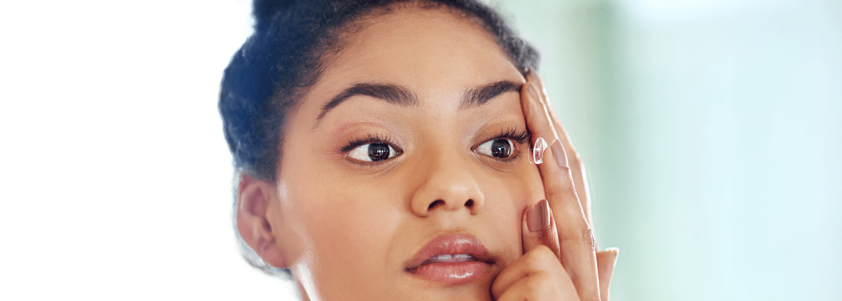 woman putting contact lens in eye