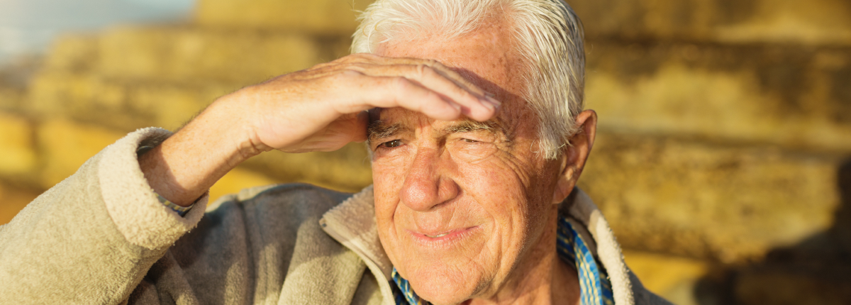 Senior male protecting eyes from sun